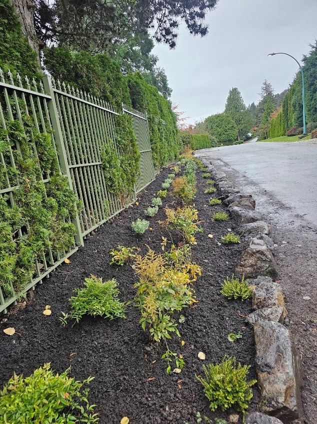 Finished planted and mulched garden bed with rock border