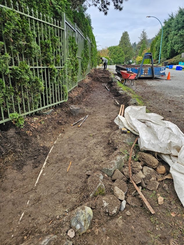 Garden bed excavation and site prep along a metal fence