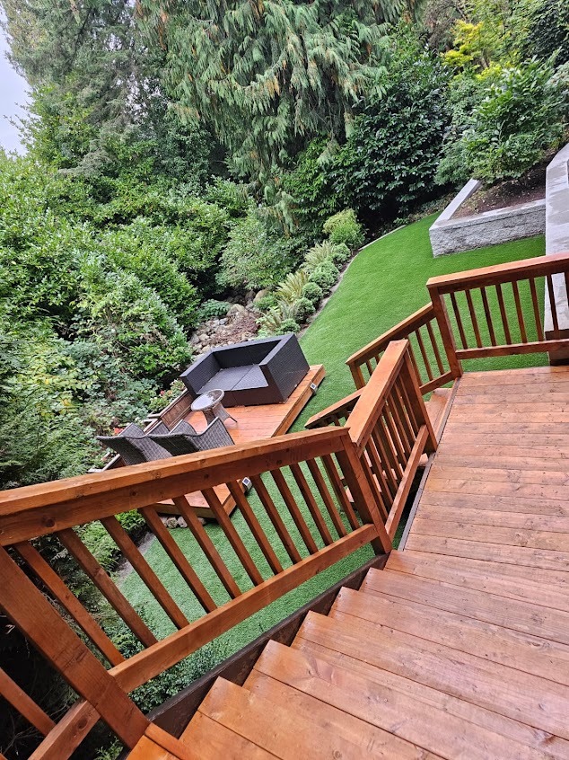 Finished multi-level backyard with wooden stairs, seating, and lawn