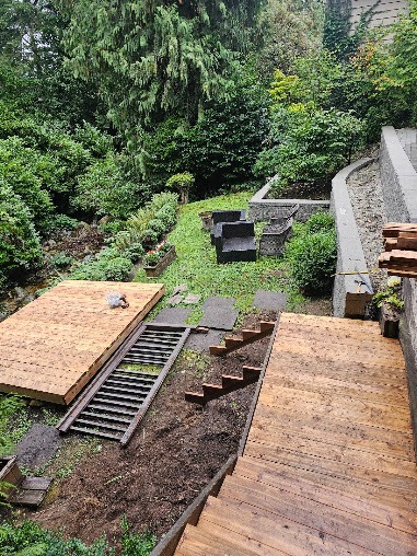 Backyard renovation in progress with stairs and deck framing